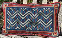 Chevron geometric needlepoint small lumbar cushion in red, old blues, copper and sand colors